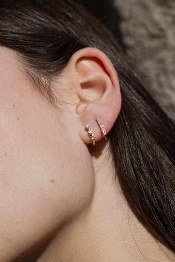 Gamme Blanche Mono boucle en La Sensationnelle or 375 ( 9 carats ) & Diamants blancs naturels Matériaux : Or 375 ( 9 carats )  Pierre : 7 Diamants blancs naturels SI2 / diam. 1,5 mm - total de 0,27 cts  Diamètre extérieur de la boucle : 10 x 11 mm  Poids de la boucle : 1,74 g - une vraie plume sur l'oreille  Dessinée en France, réalisée en Inde Fabrication : Jaipur, Inde