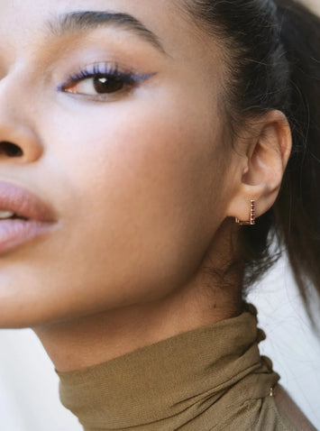 Gamme Blanche - Mono boucle en La Sensationnelle or 375 ( 9 carats ) & Grenats Matériaux : Or 375 ( 9 carats )  Pierre : Cinq Grenats - 2 mm - total de 0,54 cts  Dimensions de la boucle : 10 x 11 mm  Poids de la boucle : 1,74 g - une vraie plume sur l'oreille  Dessinée en France, réalisée en Inde Fabrication : Jaipur, Inde Un design épuré, élégant et discret à porter en toutes occasions seule ou en pair.