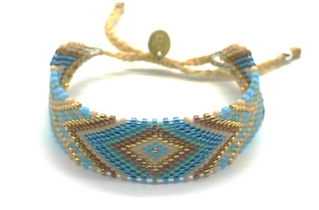 Myuki est une marque d'Amérique latine.  Manchette moyenne tissée en perle de verre dans les ateliers.  motifs : triangle bleu turquoise doré marron  Embouts fermoir en argent  Hand made