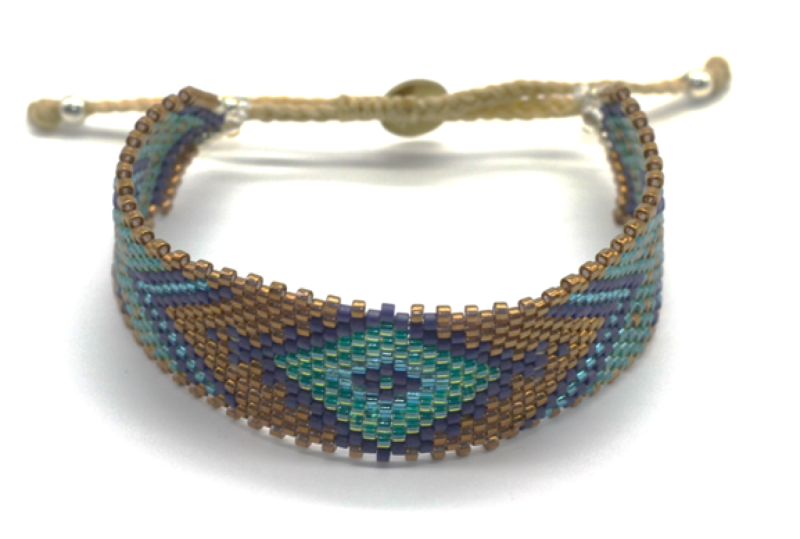 Myuki est une marque d'Amérique latine.  Manchette moyenne tissée en perle de verre dans les ateliers.  motifs : triangle bleu turquoise doré marron  Embouts fermoir en argent